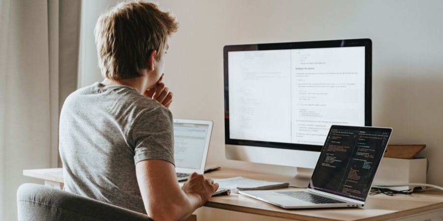A man writing code on his computer. 